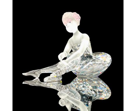 Sparkling faceted and molded crystal figurine modeled as an adorable little ballerina tying her ballet slippers. Pink scrunch