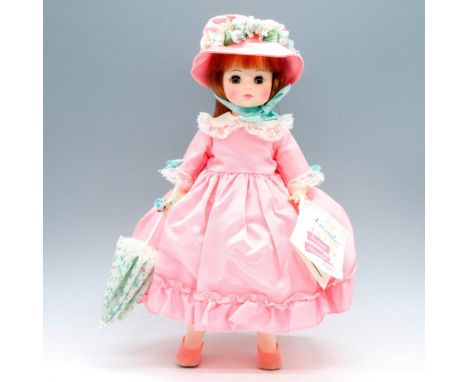 Original Lucinda doll dressed in a pink dress, a white petticoat, a parasol and a flower bonnet tied under her chin. Item has