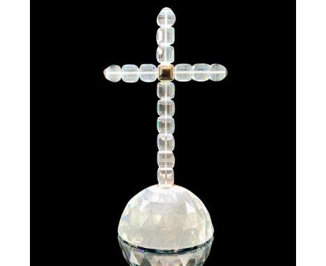 A clear crystal figure of a cross made of multiple square crystals connected by rhodium with a crystal circular base. Swarovs