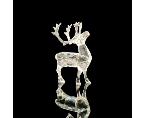A clear crystal figure of a reindeer with large antlers and his head facing upwards. Melon colored crystal used for the eyes.