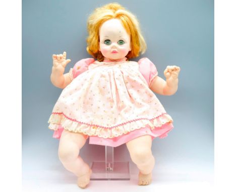 Baby doll dressed in a pink and white rose print apron dress. This item has its original box. Certificate of Authenticity inc