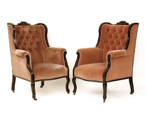 A pair of late Victorian ebonised armchairs, with pink button backs