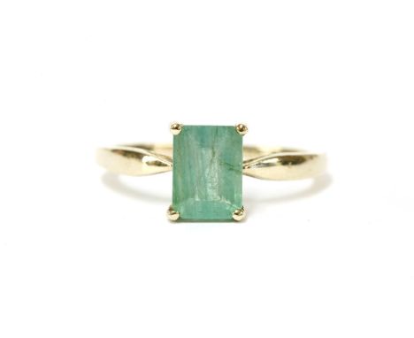 A 9ct gold single stone emerald cut emerald ring, to open shoulders and a plain polished shank, size N½