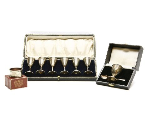 Cased silver items: a set of 6 small cups, by Robert Pringle, London 1916, an egg and spoon christening set and a napkin ring