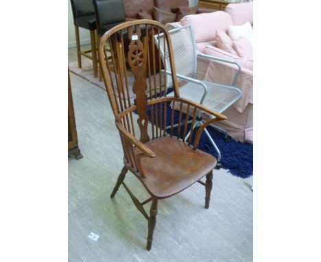 A late Victorian elm and ash comb back Windsor chair, the solid seat raised on turned legs       CA