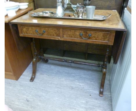 A modern walnut finished sofa table, having twin drawers, over opposing vase shaped columns, raised on splayed legs  30''h  3