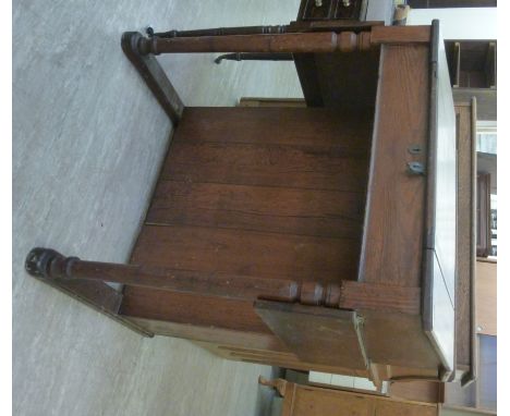 A late Victorian stained pitch pine clerk's desk, the angled box top with a hinged scriber, enclosing a fitted interior, the 