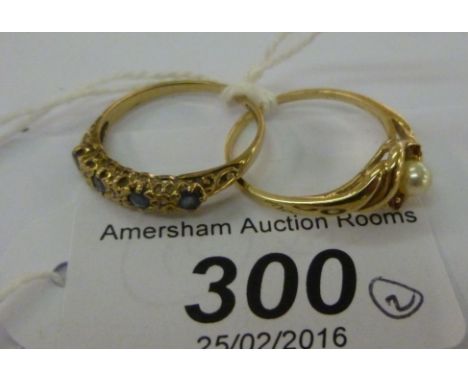 Two 9ct gold rings, one set with a seed pearl and two garnets, the other with sapphires and diamonds       11