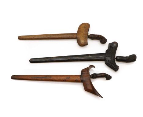Three Indonesian kris,  19th century and later, each with carved wood handles and scabbards, two with wavy blades,  56cm, 49c