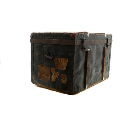A leather mounted and banded trunk, early 20th century, with two locking hinges, the exterior with remnants of luggage tags, 