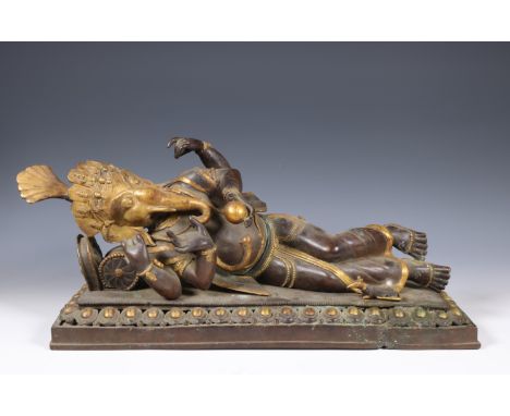 Thailand, bronze partly gilded sculpture of reclining Ganesha, ca. 1900; With four arms and fine crown, on lotus throne.  l. 