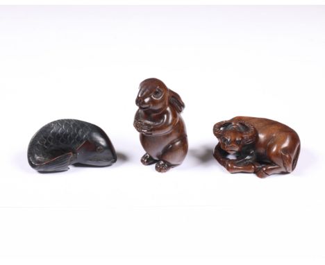 Japan, three boxwood netsuke, 20th century, comprising a hare, signed, a buffalo and a fish l. 4,5 cm max. [3]