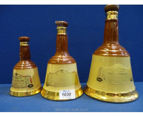 A trio of Wade Bell's Old Scotch Whisky decanters:  one small (empty), one medium (part used) and a large bottle (unopened).