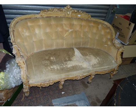 An imposing French design serpentine fronted Sofa buttoned upholstered in beige and with carved and gesso show frame and stan