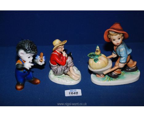 A small Bavarian figure of a boy pushing wheelbarrow, Goebel figure of hedgehog with bee and boy sitting with dog, marked 'No