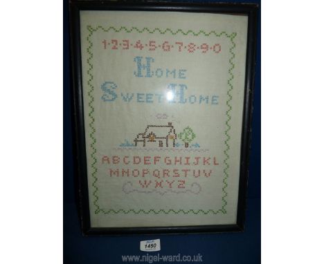 A child's linen and multi coloured wool sampler displaying a house, alphabet, numbers etc. in ebonised slender frame, 12" x 1