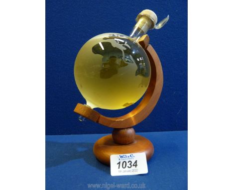 A novelty decanter in the form of a small globe on stand with contents of Highland Malt Scotch Whisky.