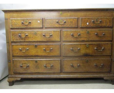 A George III mahogany crossbanded oak chest having a three quarter hinged top, over five facsimile drawers and four short dra