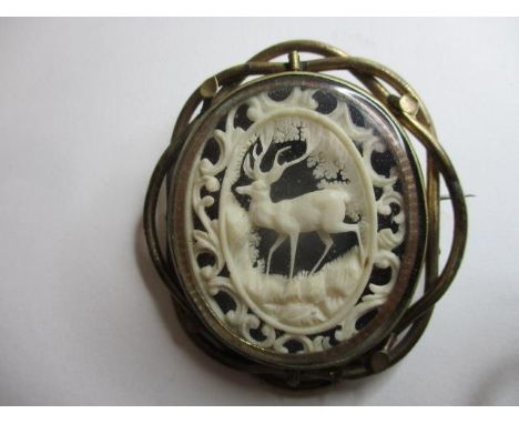 A Victorian gold plated brooch, the rotating centre set with an ivory panel of a stag and scrolls, with a photographic portra