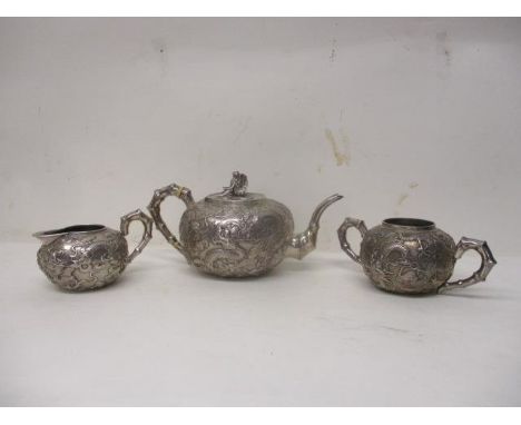 A late 19th/20th century Chinese silver three piece teaset by Wai Kee Hong Kong of bulbous form, embossed and chased with dra