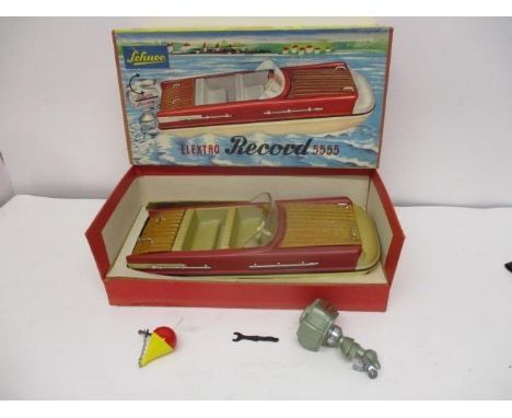 A Schuco 'Elektro Record 5555' toy boat with a detachable outboard engine, a buoy with an anchor attached and a spanner, boxe