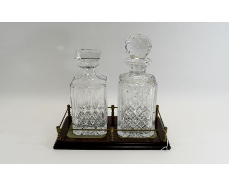 Glass Decanter Set comprising two decanters with star cut bases and stoppers, housed in a mahogany effect stand.