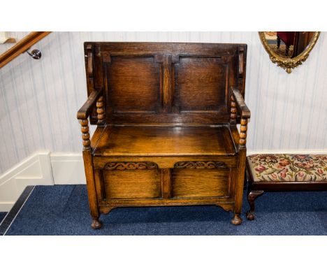 Monks Bench Dark Oak settle with hinged flip seat, carved front panel and carved ball feet. Approx dimensions 32 inches in wi