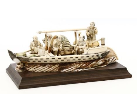 Okimono. Boot mit vier Figuren und Ladung. Elfenbein, geschnitzt. Japan, Meiji-Periode, Ende 19. Jh. L. 22 cm. Auf Holzsockel