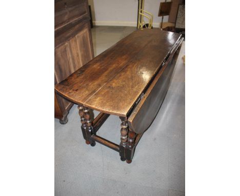 An 18th century oak oval gate leg dining table, on slender turned supports, 54" wide 