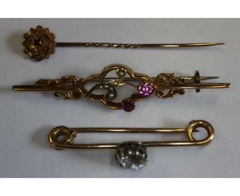 A 9ct gold and paste set bar brooch, 2.4g, a 9ct gold, seed pearl and paste set bar brooch, 1.8g, and a 15ct gold mounted sti