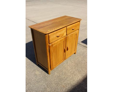 A pair of light oak side cabinets, fitted two drawers over cupboards, on stile supports, 37" wide x 16" deep x 33" high 