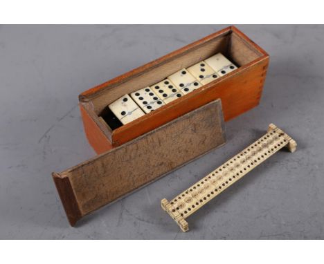 A carved bone cribbage board, 6 1/4" wide, and a bone and ebony dominoes set, in box 