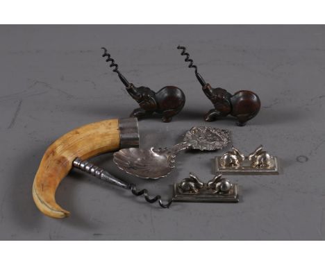 A silver mounted boar's tusk corkscrew, a Continental silver caddy spoon, stamped Sterling,&nbsp; two corkscrews with elephan