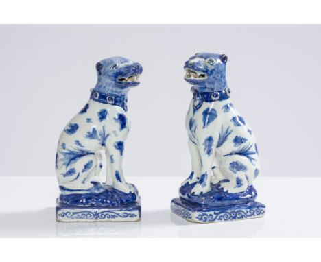 A pair of fine Dutch Delft blue and white sculptures of seated hounds on a base, 1st half 18th C.H 20 - 19,5 cm Provenance:- 