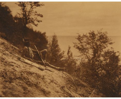 Roland W. Reed (American, 1864-1934). Photogravure titled "End of Day" depicting an Ojibwe Native American man resting on a r