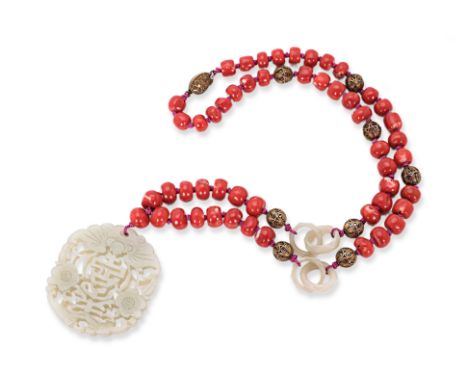 A CARVED JADE AND CORAL BEAD NECKLACE The celadon jade carved and pierced pendant decorated with bats, flowerheads and centra