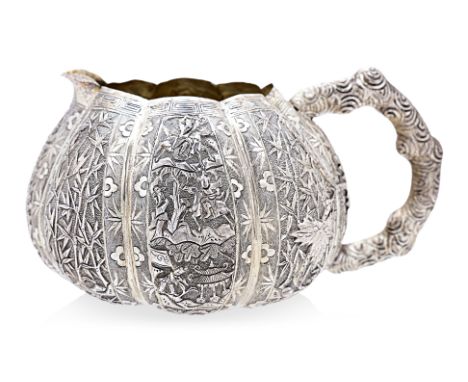 A CHINESE EXPORT SILVER MILK JUG
Repousse and chasing, gold washed interior, gourd shaped with eight lobed panel sections, sm
