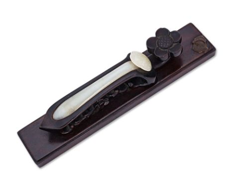 A JADE RUYI-FORM HAIRPIN ON CARVED HARDWOOD STAND The carved celadon jade hairpin of slightly tapering form, the head carved 