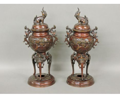 A pair of Japanese bronzed censers, with scrolling handles to either side, tripod supports and circular bases, each approxima