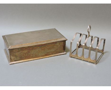 A silver engine turned cigarette box, bears engraving, and a silver toast rack