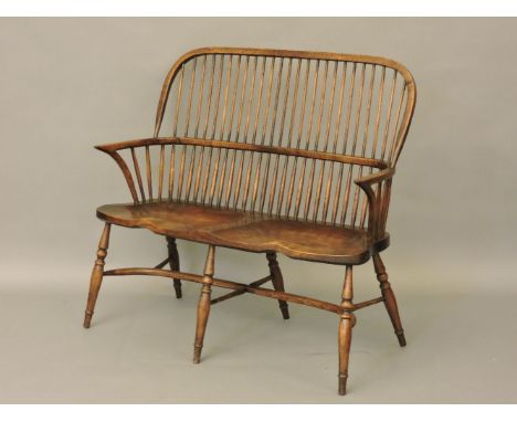 A double Windsor stick back settee, with crinoline stretcher, 107cm wide