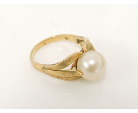 A gold single cultured pearl ring, with textured leaf three prong shoulders, marked 18, 5.42g