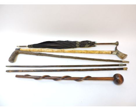 A knobkerrie, with carved serpent entwined shaft, a silver topped umbrella, Japanese carved bone walking stick, and three oth