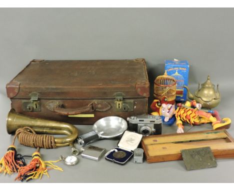 A leather packing case, containing a quantity of miscellanea, to include a bugle, camera, medallion, etc