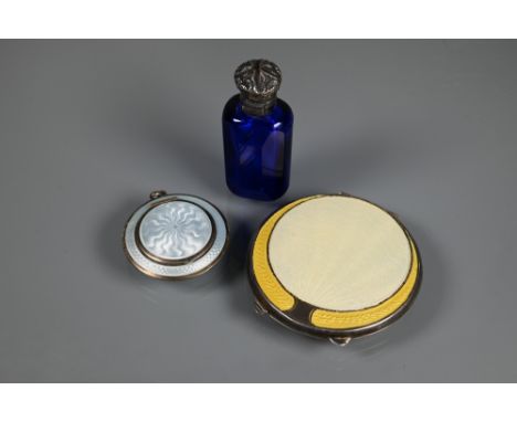 An Art Deco silver and yellow enamel powder compact, Birmingham 1920, 7 cm diam; a locket silver and pale blue guilloche enam