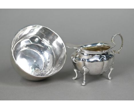 A silver cream jug with scroll handle and four supports, George Unite, Birmingham 1908, to/w a plain sugar basin with reeded 