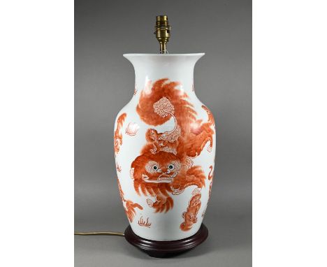 A Chinese red and white baluster vase (mounted as a lamp on hardwood stand) painted in iron red enamels with playful guardian