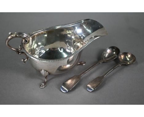 An Edwardian silver sauce boat with scroll handle and hoof feet, Birmingham 1909, to/w a Victorian salt ladle and mustard spo