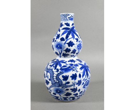 A 19th/20th century Chinese blue and white double gourd vase painted with two sinuous dragons amongst trailing foliage, bloss