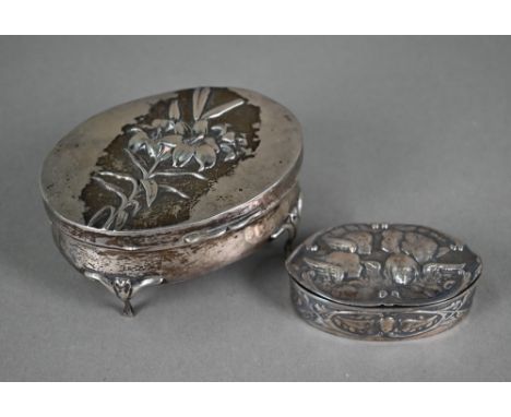 An Edwardian oval silver ring-box, the hinged cover, embossed with lilies, enclosing fitted velvet lining, William Comyns &am